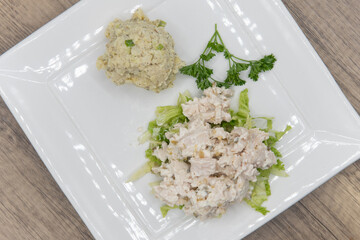 Overhead view of loaded turkey salad sandwich served without the bread and a side order scoop of potato salad