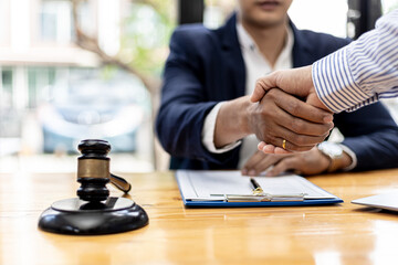 Lawyer and client shake hands, sign a lawsuit for the client, in which the client has filed a lawsuit against an employee of a company that commits fraud. The concept of litigation counseling.