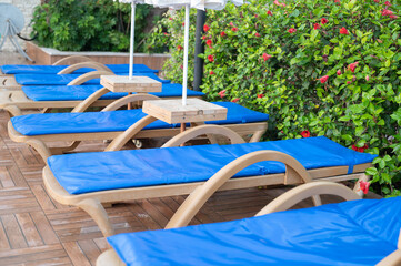 Obraz na płótnie Canvas Relaxing lounge chairs by the swimming pool