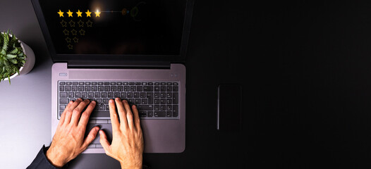 Five Star Rating with person using a laptop on a white table