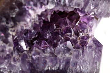 Macro Mineral Stone Amethysts in the rock on a white background