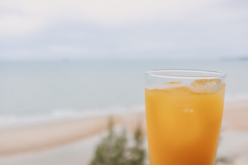 Fresh juice in a glass with sea view background in concept of summer.