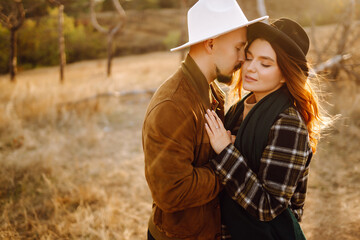 Young couple walking in the autumn park. Enjoying time together. Love story. Autumn style.