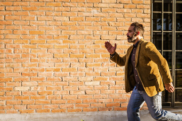 Modern businessman with beard  running in a hurry on the street.