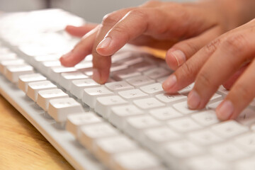 Female office worker typing on the keyboard
