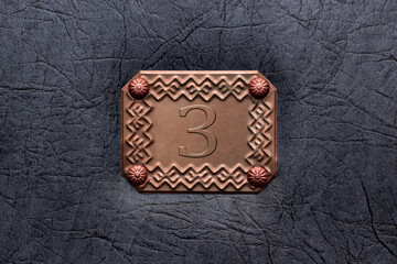 bronze frame on the door, wall with number 3, third seat concept