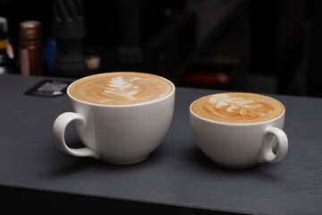 two cups of cappuccino on a gray bar counter