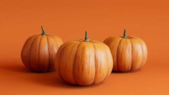 Three Pumpkins on a Orange colored background. Autumn themed Image.
