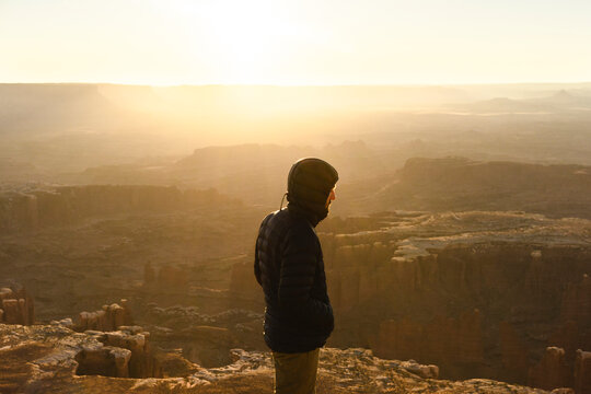 man hiking at sunrise in canyonlands national park in the summer in moab uath