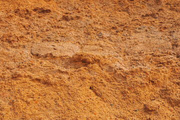 Coarse industrial sand texture. Yellow sand with small pebbles for use in road construction and manufacturing. View from above