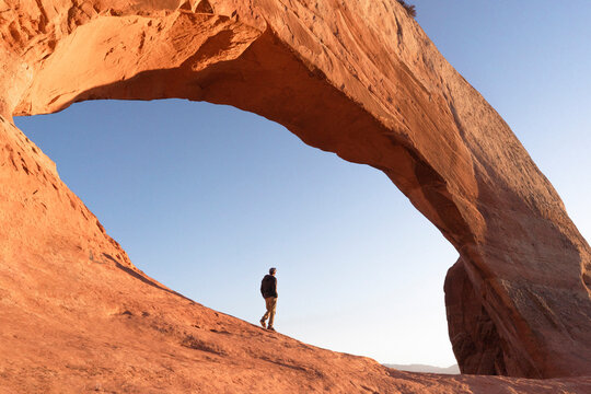 man hikig in arches national park at sunrise in moab utah