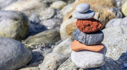 Zen balance stones, smooth rocks pyramid stacked on pebble beach background.