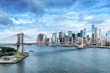 Brooklyn Bridge and Downtown Manhattan in New York City on a partially cloudy day. - obrazy, fototapety, plakaty