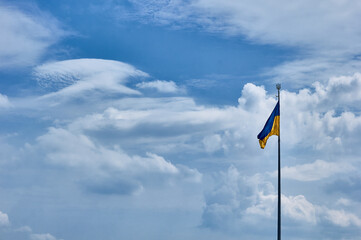 Ukrainian blue and yellow flag. Background of blue sky and white clouds. The national flag of Ukraine. 
