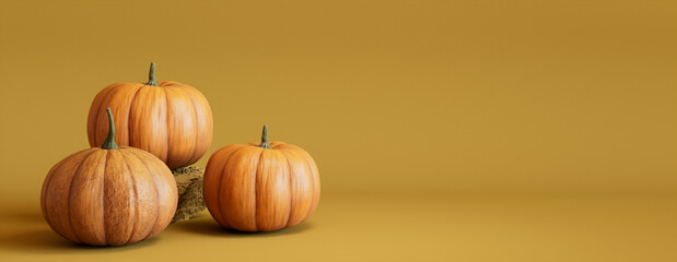 Three Pumpkins on a Mustard Yellow colored background. Fall themed Banner with copy-space.