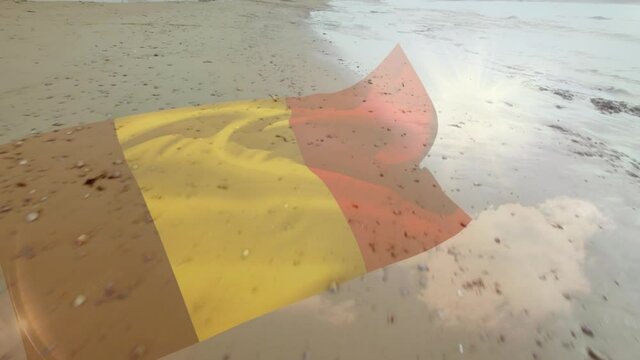 Digital composition of waving belgium flag against aerial view of the beach