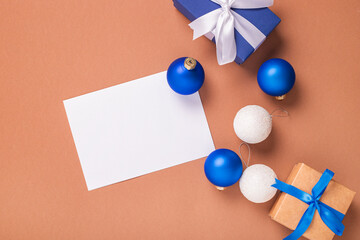 Gift boxes, Christmas tree decorations and greeting card for text on a brown background. Concept for New Years and Christmas Eve. Banner. Flat lay, top view