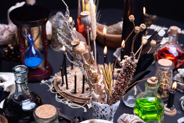 Witchcraft still life with witch weeds selective focus at front. Esoteric gothic and occult witch table for Halloween. Various magic objects and ritual arrangement with symbols. Gothic Halloween.