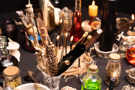 Witchcraft still life with witch weeds selective focus at front. Esoteric gothic and occult witch table for Halloween. Various magic objects and ritual arrangement with symbols. Gothic Halloween.