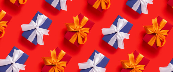 Lots of Christmas gift boxes on a red background. Top view, flat lay. Banner