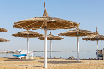 Beautiful beach scene with palm trees and perfect blue sea water. view of an empty beach with white beach umbrellas and turquoise clear water