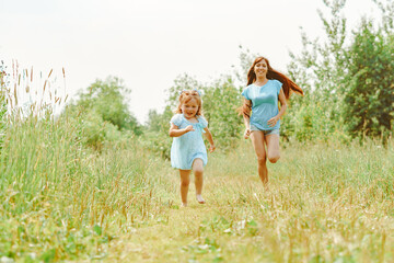Fototapeta premium daughter runs towards her mother on the grass