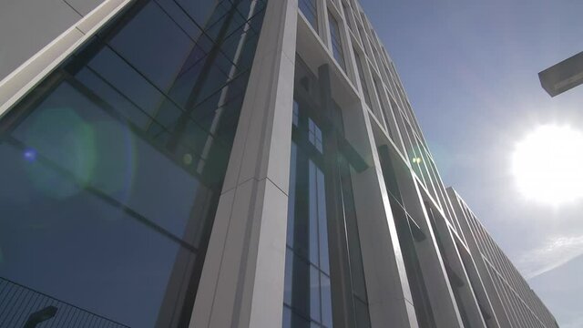 Modern office building architecture windows low angle lens flare stabilized gimbal