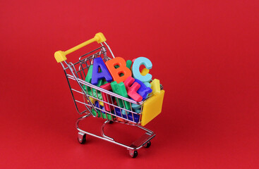 Plastic letters in a miniature shopping cart