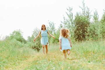 Obraz premium daughter runs towards her mother on the grass