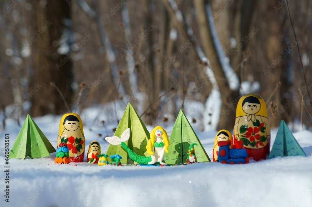 Wall mural Fairy-tale characters in a snowy forest. Matryoshka, wizard, mermaid, paper Christmas tree and dwarf.