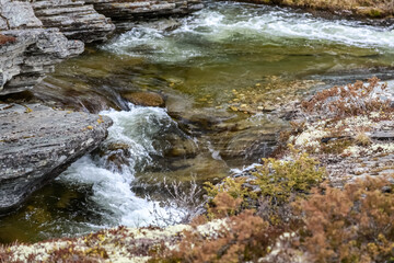 Naklejka na ściany i meble water flowing over rocks Høvringen, Rondane, Norway, spring