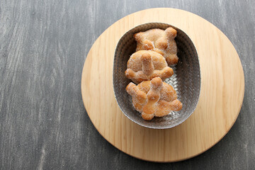 Delicious, fresh, sugary and freshly made Mexican dead bread that is made for the Day of the Faithful Dead and All Saints that is celebrated in November in Mexico in a handmade woven basket
