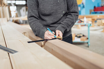 Carpenter using a right angle tool or carpenters square