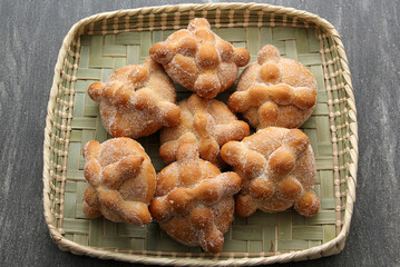 Delicious, fresh, sugary and freshly made Mexican dead bread that is made for the Day of the Faithful Dead and All Saints that is celebrated in November in Mexico in a handmade woven basket
