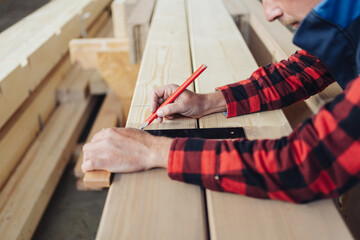 Fototapeta na wymiar Hands of a carpenter using a right angle tool or square