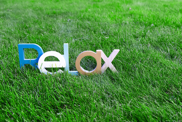 Wooden lettering "Relax" in green meadow