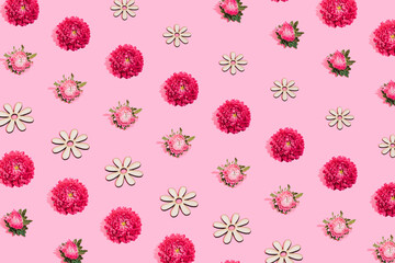 Vibrant pink flowers pattern on pastel pink background. Minimal isometric idea made of burgeon,blooming and wooden flower. Flat lay concept.