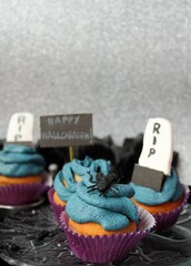 Halloween pastry: cupcakes with decoration of "happy Halloween", RIP tombstones, insects, pumpkins flowers with skulls