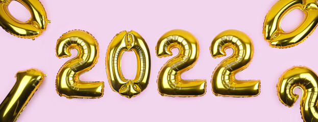 2022 banner with golden foil balloons on pink background. Numbers 2022 gold balloons on pink wall . New Year's card. Happy new year celebration party background. Greetings and congratulation concept