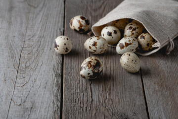 Quail eggs in a bag on an old wooden table