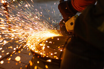 Spark grinder. Hot white sparks when cutting steel material. Industrial worker cutting metal with a...