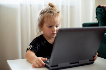 Cute little girl playing with plastic computer toy. Toddler with educational toys laptop for children