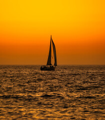 Obraz na płótnie Canvas Sailboat Silhouette Ocean Sunset Vertical 
