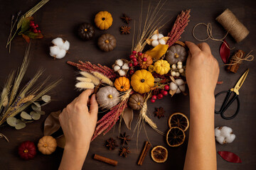 Diy rustic autumn table decoration. Floral interior decor for fall holidays with handmade pumpkins. Flatlay, top view