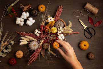 Diy rustic autumn table decoration. Floral interior decor for fall holidays with handmade pumpkins. Flatlay, top view