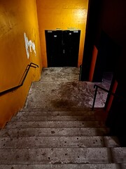 Escalier sur porte de sortie  éclairé dans la nuit , dans bâtiment grunge 