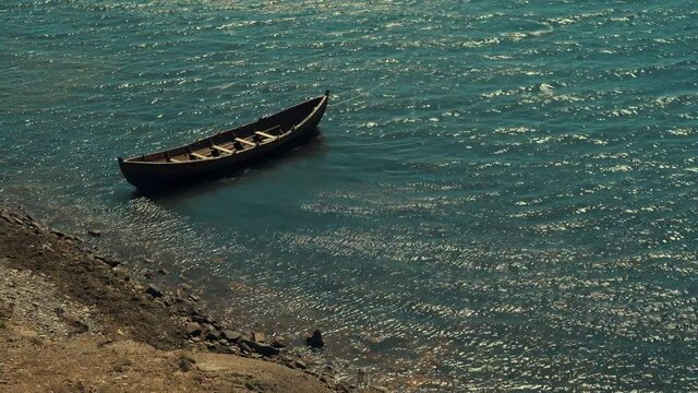 An old boat on the seashore similar to the Viking drakar from the past. A large boat for several people