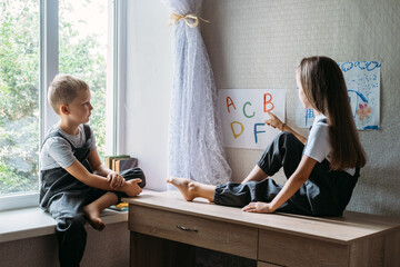 Back to school, Homeschooling, online study, home quarantine online learning education. Schoolchildren kids reading books and learn letters at home during home schooling