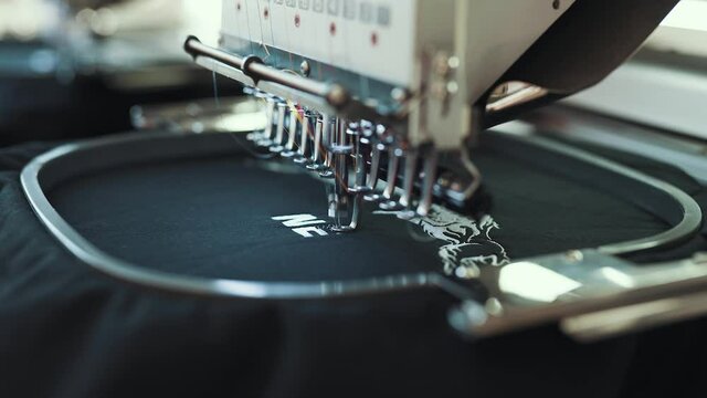 Stickmaschine in der Näherei stickt ein Logo in den Stoff | Nähmaschine in Österreichischer Produktion stickt auf dem Stück Leder.  | 4K 24 FPS 10 Bit 4:2:2 