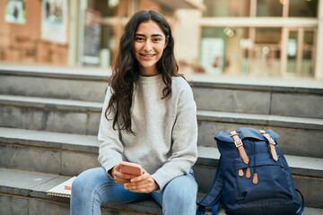 Young middle east student girl smiling happy using smartphone at the city.